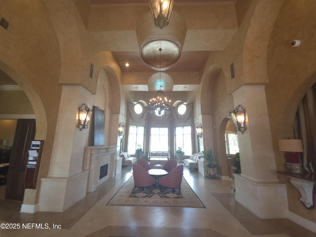 interior space with arched walkways, a fireplace, a high ceiling, and an inviting chandelier
