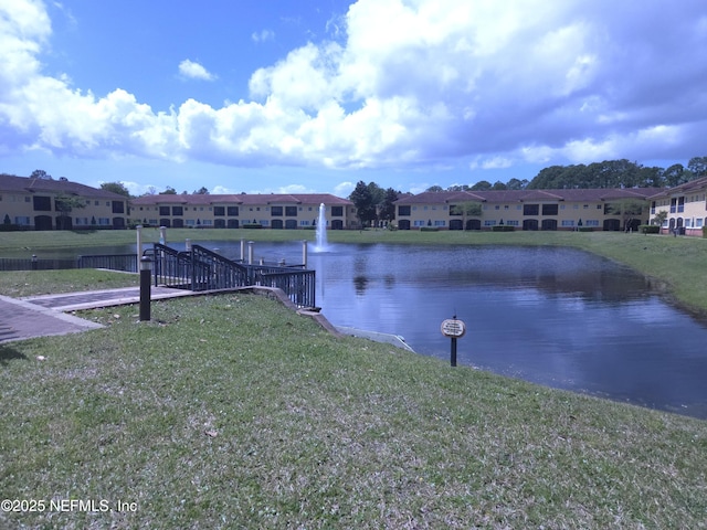 view of dock with a yard, a residential view, and a water view