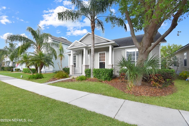 view of front of property with roof with shingles and a front lawn