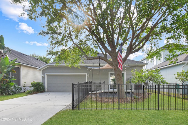 view of front of property featuring a front lawn, driveway, a fenced front yard, and a garage