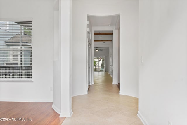 corridor with light tile patterned floors and baseboards