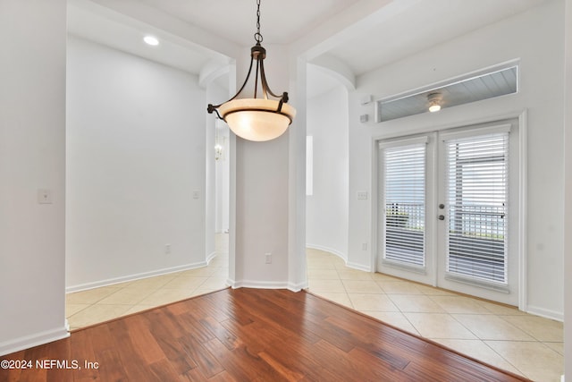 unfurnished dining area featuring french doors, recessed lighting, baseboards, and wood finished floors