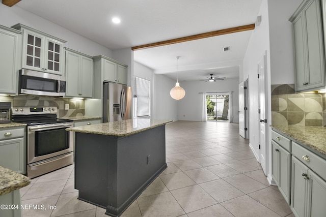 kitchen featuring open floor plan, decorative backsplash, light tile patterned flooring, beam ceiling, and appliances with stainless steel finishes