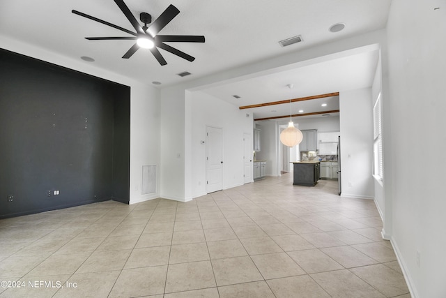 unfurnished living room with baseboards, visible vents, light tile patterned floors, and a ceiling fan