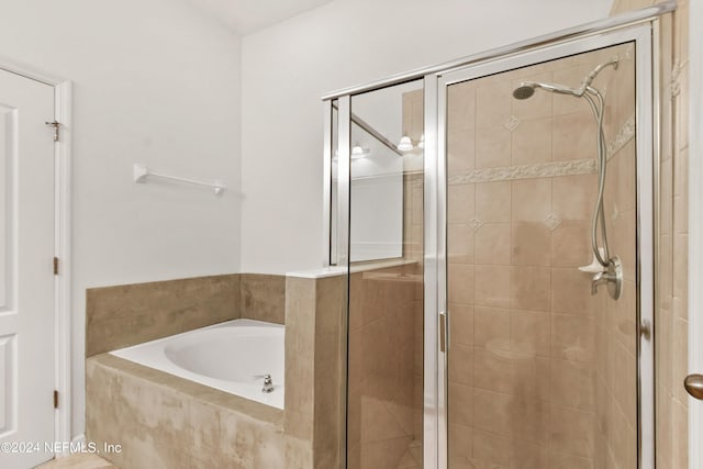 bathroom featuring a stall shower and a garden tub