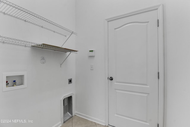 clothes washing area featuring hookup for an electric dryer, light tile patterned floors, baseboards, laundry area, and washer hookup
