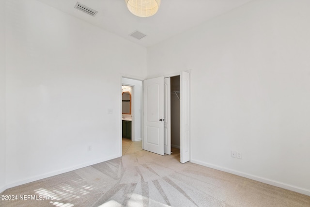 unfurnished room featuring baseboards, light colored carpet, and visible vents