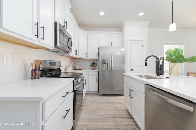 803 12th Ave S, Jacksonville Beach, FL 32250 - kitchen with appliances with stainless steel finishes, a sink, crown molding, light countertops, and backsplash