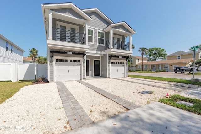 803 12th Ave S, Jacksonville Beach, FL 32250 - view of front of home featuring a balcony, driveway, a garage, fence, and a gate