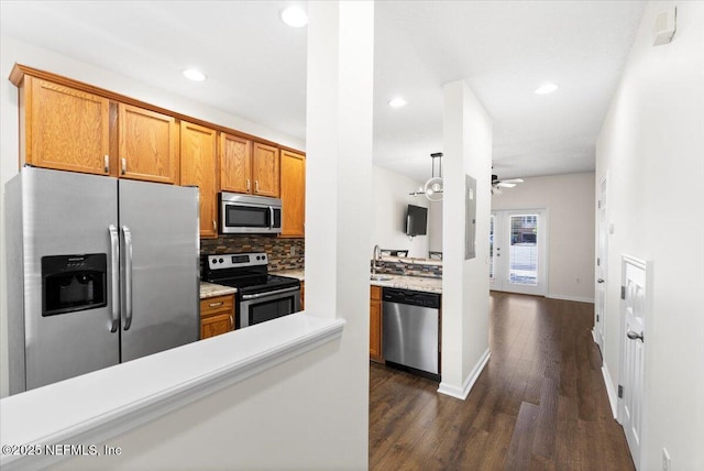 1492 Fieldview Dr, Jacksonville, FL 32225 - kitchen with light countertops, tasteful backsplash, appliances with stainless steel finishes, brown cabinets, and dark wood-style floors