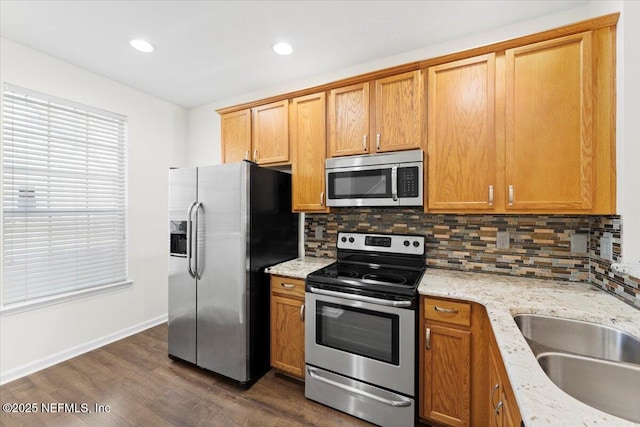 1492 Fieldview Dr, Jacksonville, FL 32225 - kitchen featuring dark wood-type flooring, decorative backsplash, a sink, light stone countertops, and appliances with stainless steel finishes
