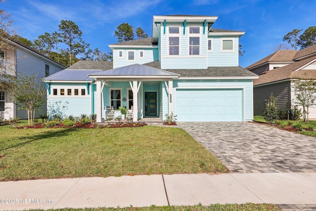 view of front of house featuring a garage, covered porch, roof with shingles, a front yard, and driveway