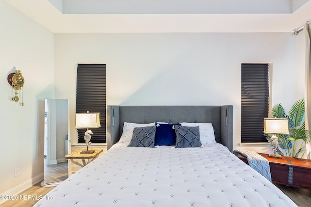 bedroom with light wood-type flooring and baseboards