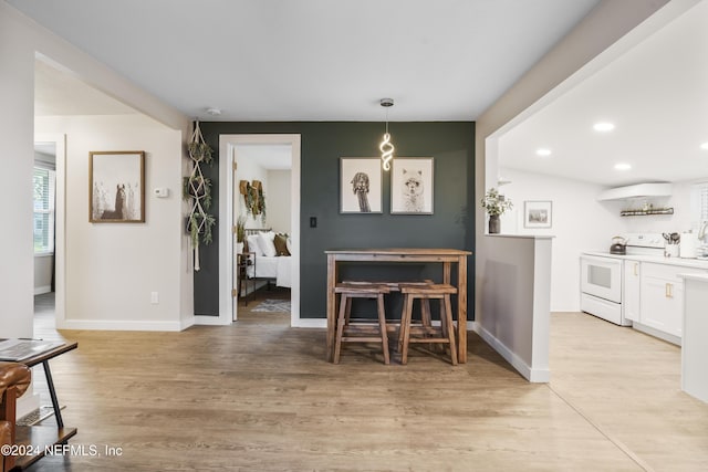 dining room with baseboards, light wood-style flooring, and recessed lighting