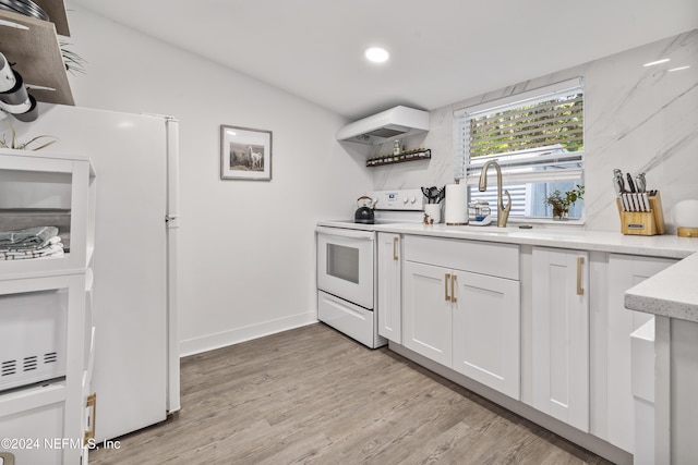 kitchen featuring white cabinets, light wood finished floors, white appliances, premium range hood, and a sink