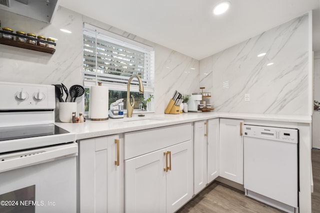 kitchen with backsplash, a sink, wood finished floors, white appliances, and white cabinets