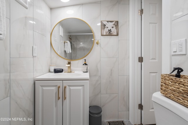 bathroom featuring tile walls, visible vents, toilet, and vanity