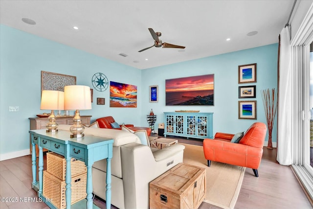 living area with a ceiling fan, recessed lighting, baseboards, and wood finished floors
