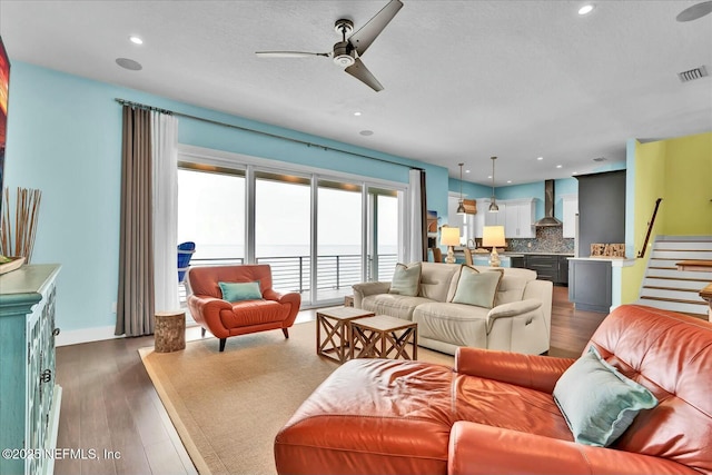 living area featuring dark wood-type flooring, visible vents, recessed lighting, and a ceiling fan