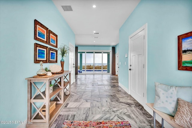 corridor with baseboards, visible vents, and recessed lighting