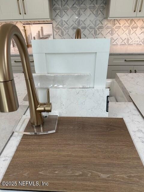 interior details featuring light stone countertops and tasteful backsplash