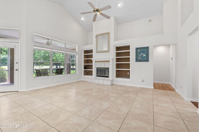 unfurnished living room with light tile patterned flooring, built in features, high vaulted ceiling, and ceiling fan