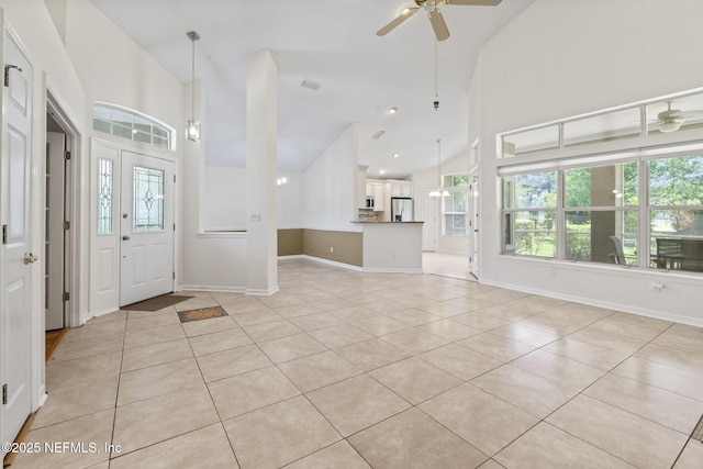 entrance foyer with high vaulted ceiling, plenty of natural light, a ceiling fan, and light tile patterned floors