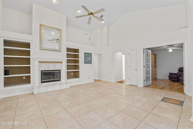 unfurnished living room featuring tile patterned flooring, baseboards, a ceiling fan, and built in features