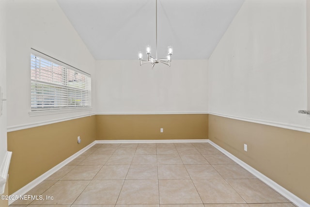 unfurnished dining area with a chandelier, vaulted ceiling, baseboards, and light tile patterned floors