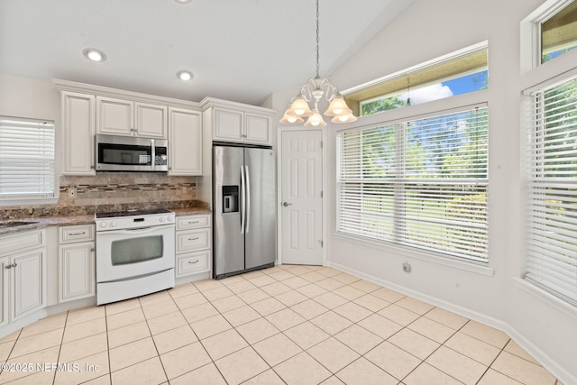 kitchen with vaulted ceiling, tasteful backsplash, stainless steel appliances, decorative light fixtures, and a notable chandelier
