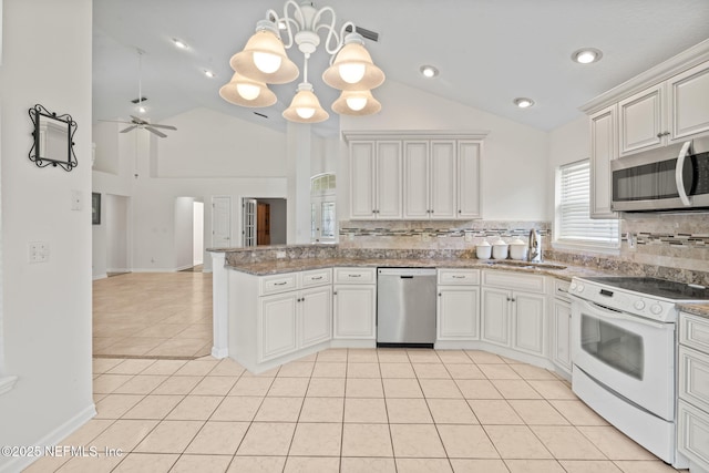 kitchen with a sink, light tile patterned floors, stainless steel appliances, backsplash, and a peninsula