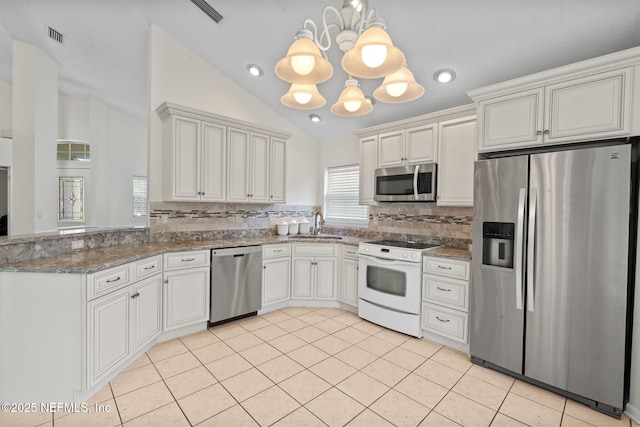 kitchen with a sink, an inviting chandelier, stainless steel appliances, backsplash, and lofted ceiling