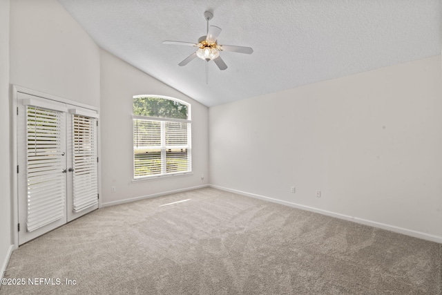 unfurnished bedroom with lofted ceiling, carpet flooring, a textured ceiling, and baseboards