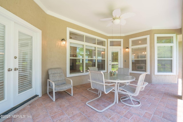 sunroom featuring stone finish floor, ornamental molding, and french doors