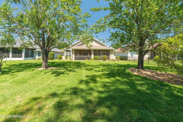 view of yard with a sunroom and fence