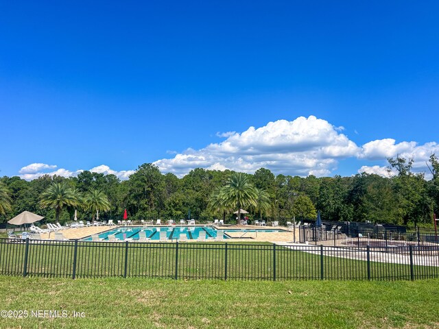 pool with a yard and fence