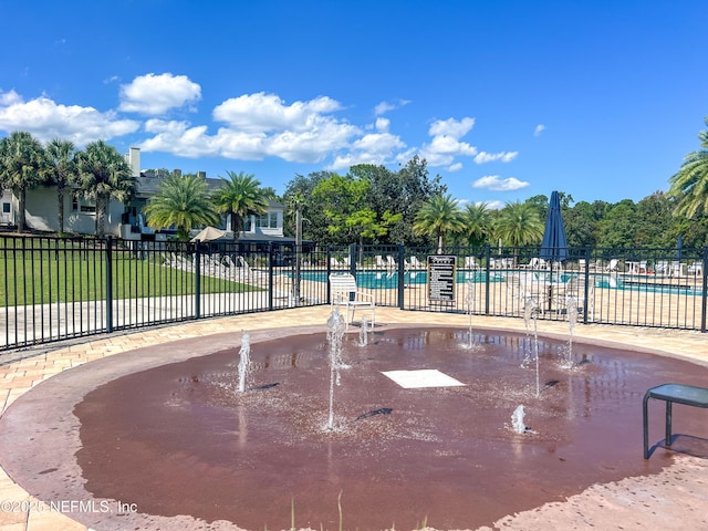 view of community featuring fence, a lawn, and a pool
