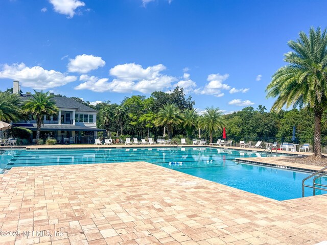 community pool featuring a patio and fence