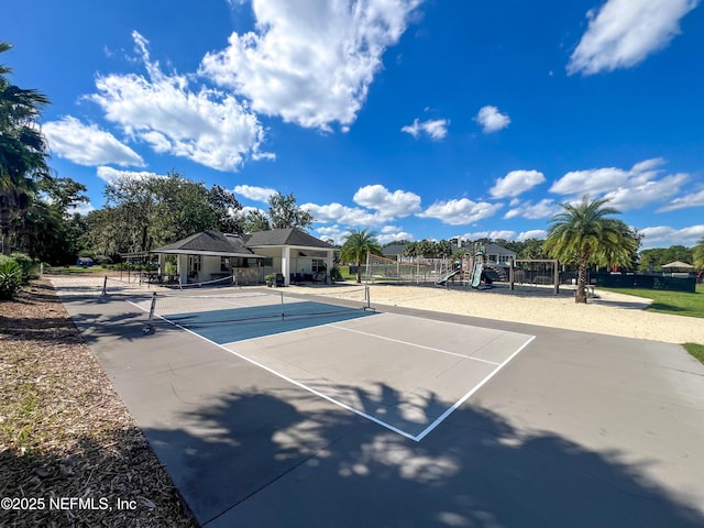 view of tennis court with fence and playground community