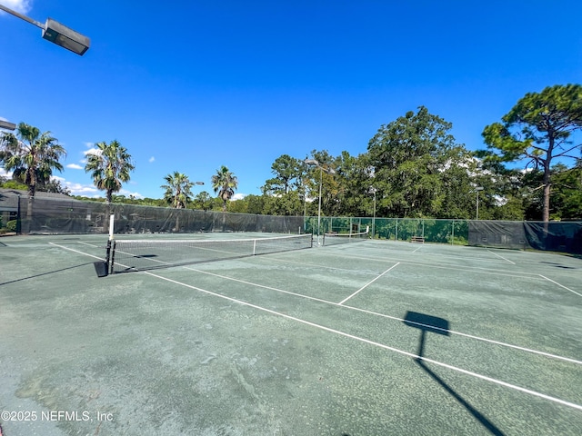 view of tennis court with fence