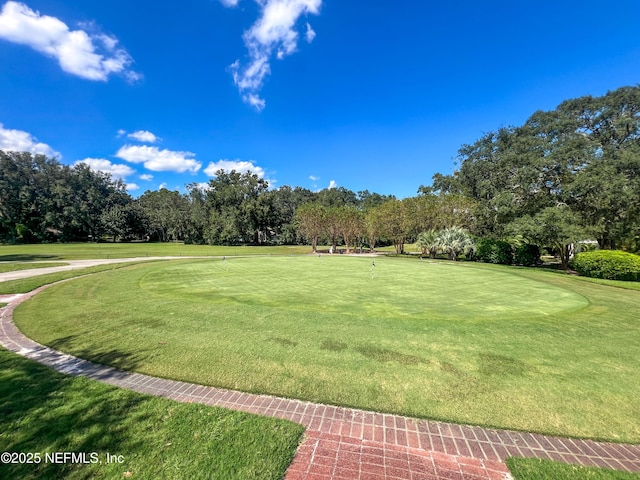 view of home's community with view of golf course and a yard