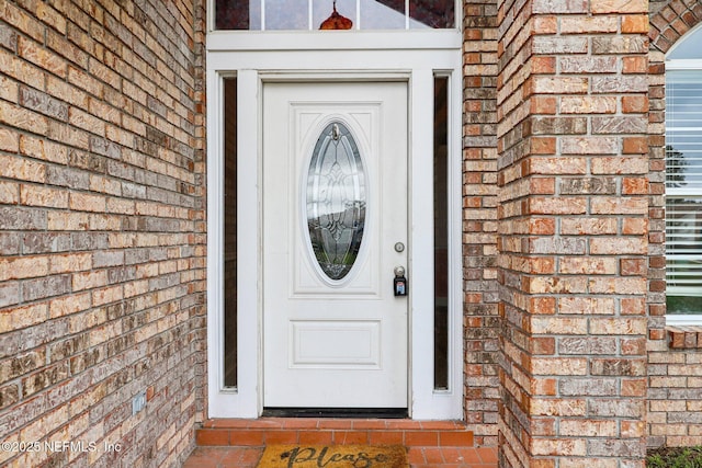 property entrance featuring brick siding