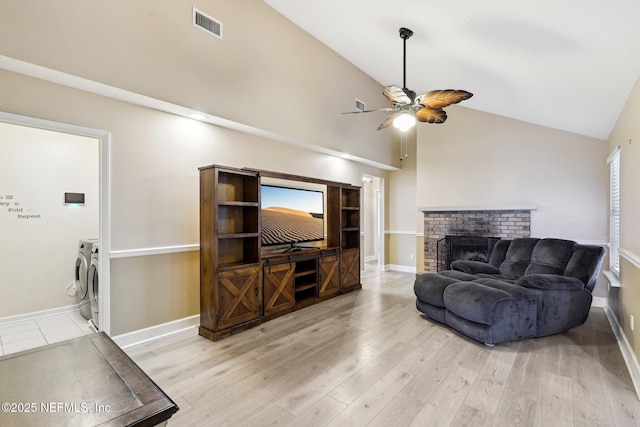 living area featuring ceiling fan, high vaulted ceiling, a fireplace, wood finished floors, and baseboards