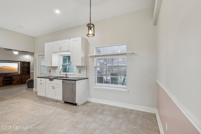 kitchen featuring a sink, stainless steel dishwasher, dark countertops, white cabinets, and decorative backsplash