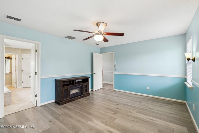unfurnished living room featuring ceiling fan, baseboards, and wood finished floors