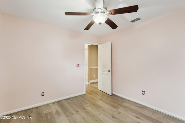 empty room with a ceiling fan, light wood-style floors, and baseboards