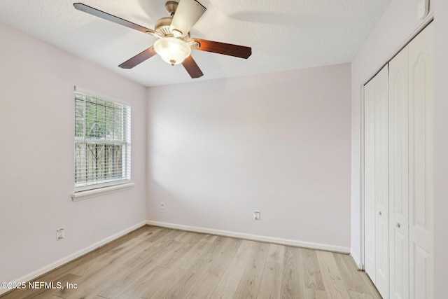 unfurnished bedroom featuring a closet, light wood-style flooring, baseboards, and ceiling fan