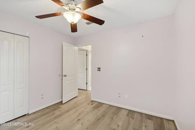 unfurnished bedroom with baseboards, light wood-style flooring, a closet, and ceiling fan