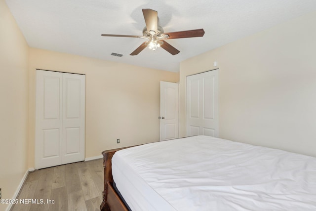 bedroom featuring light wood-type flooring, baseboards, and a ceiling fan