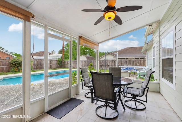 sunroom / solarium featuring healthy amount of natural light, a ceiling fan, and outdoor dining space